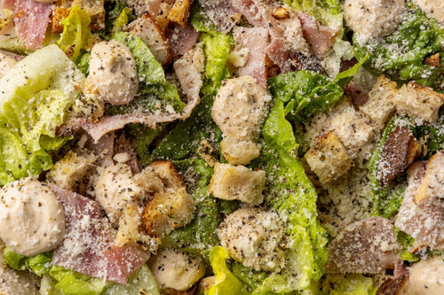 Close-up of a salad with croutons, lettuce, and other ingredients.
